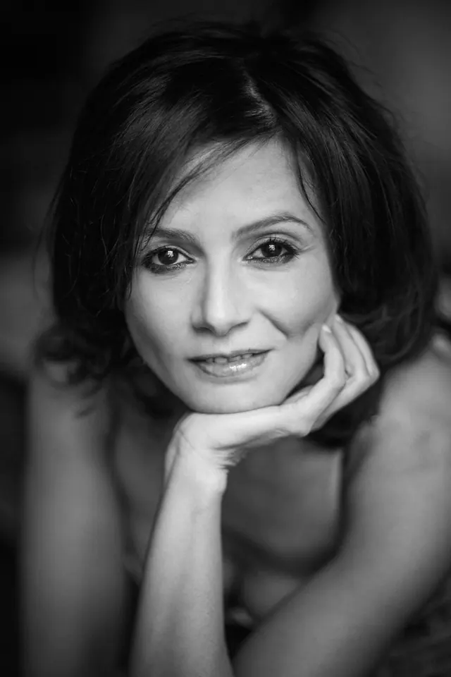 Portrait en noir et blanc de Nadia Battiston, le menton posé sur la main